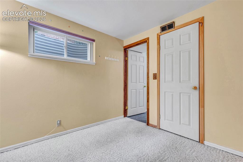 Image 15 of 26: Bedroom 1 - 6-panel doors and carpet