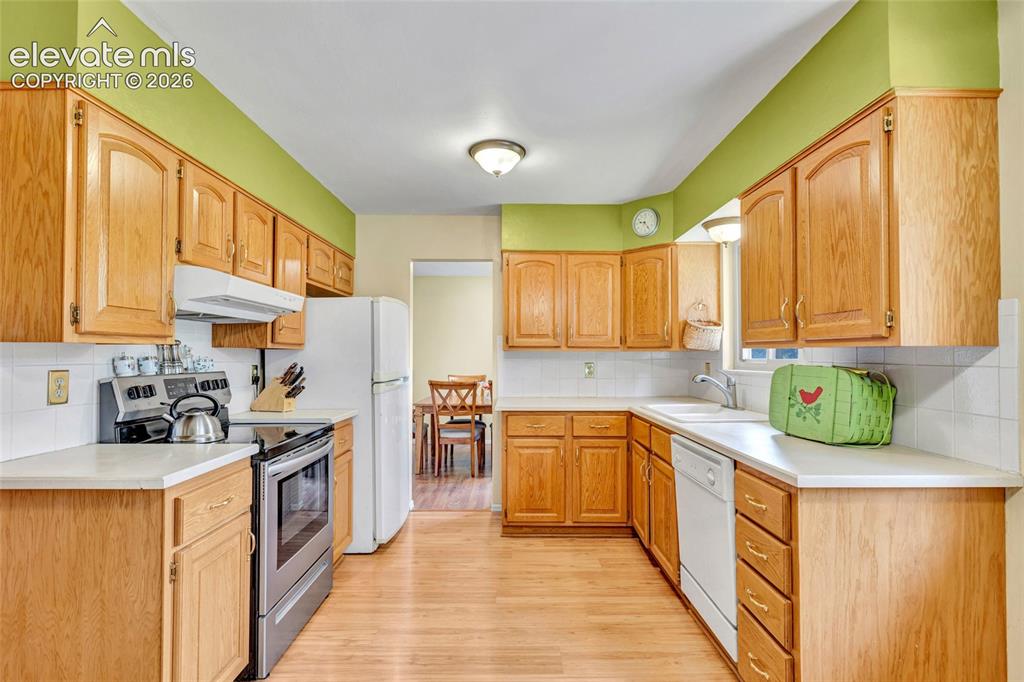Image 7 of 26: Eat-in kitchen with views of the park and pass through to dining room