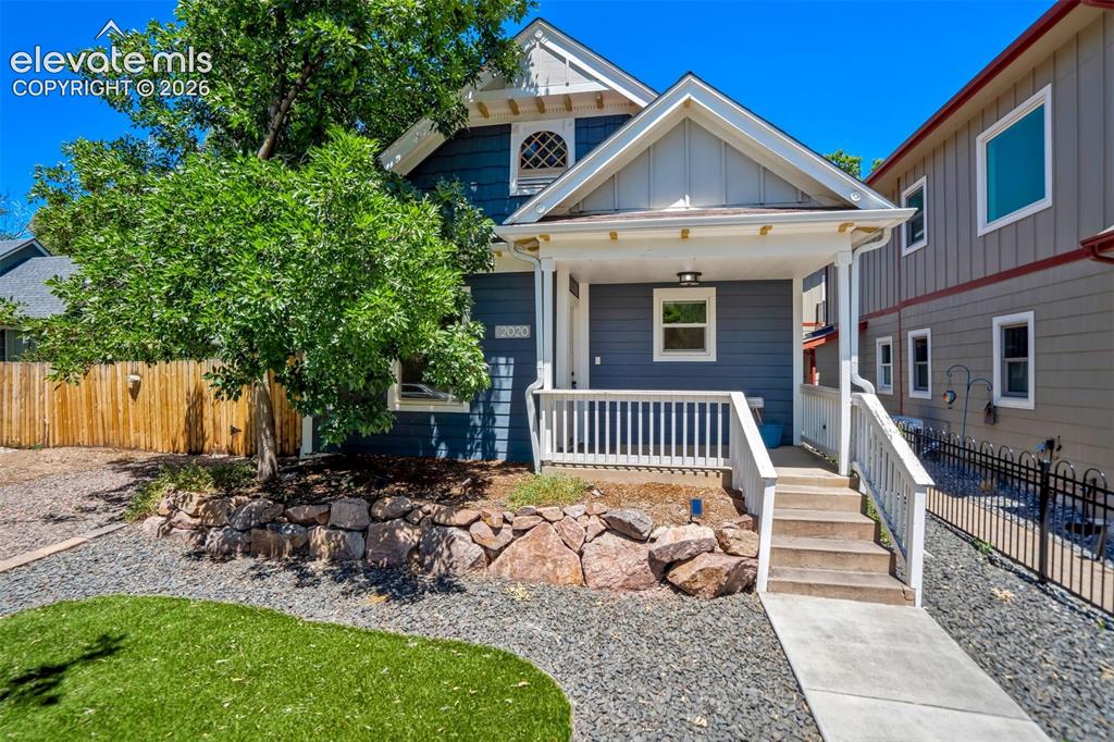 Image 1 of 50: Charming blue siding home featuring a front porch with white railings, a co