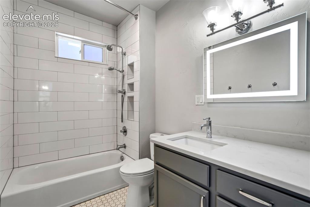 Image 16 of 50: Bathroom featuring a white subway tile shower surround, built-in shower nic