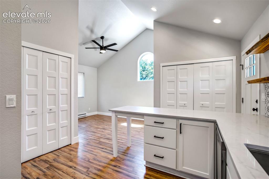 Image 34 of 50: Kitchen island with white cabinetry, black hardware, and an integrated sink