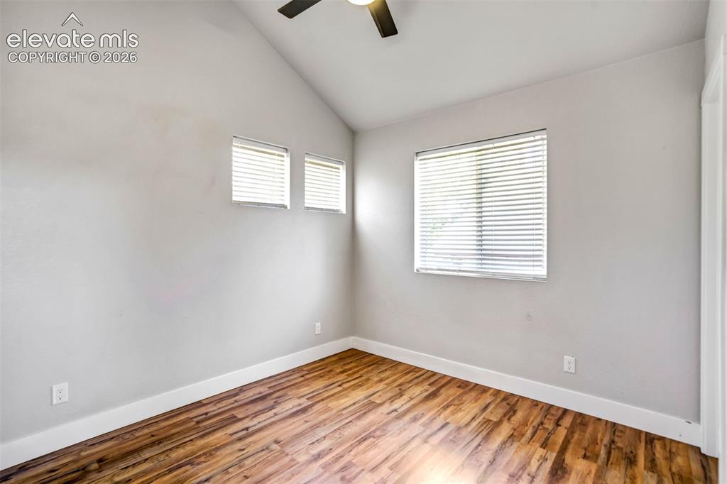 Image 36 of 50: Garage apartment with vaulted ceiling with a ceiling fan, wood-finish floor
