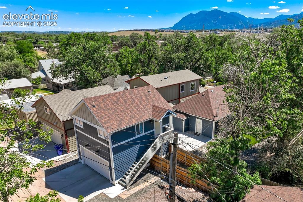 Image 46 of 50: Alley view of garage and ADU Multi-level residence featuring a mountain bac