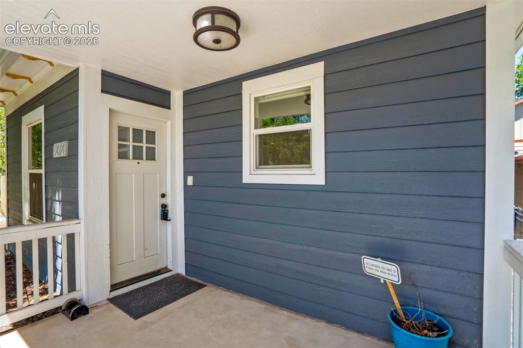 Image 6 of 50: Covered porch entry featuring a multi-pane door, horizontal siding, exterio