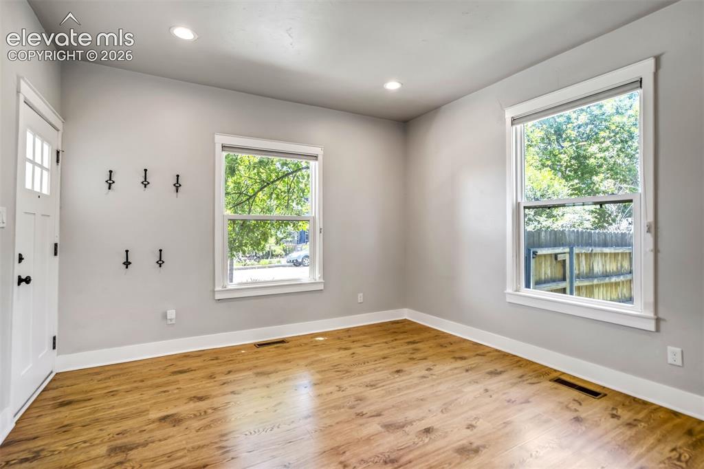 Image 9 of 50: Bright room featuring wood-finish flooring, recessed lighting, and ample na