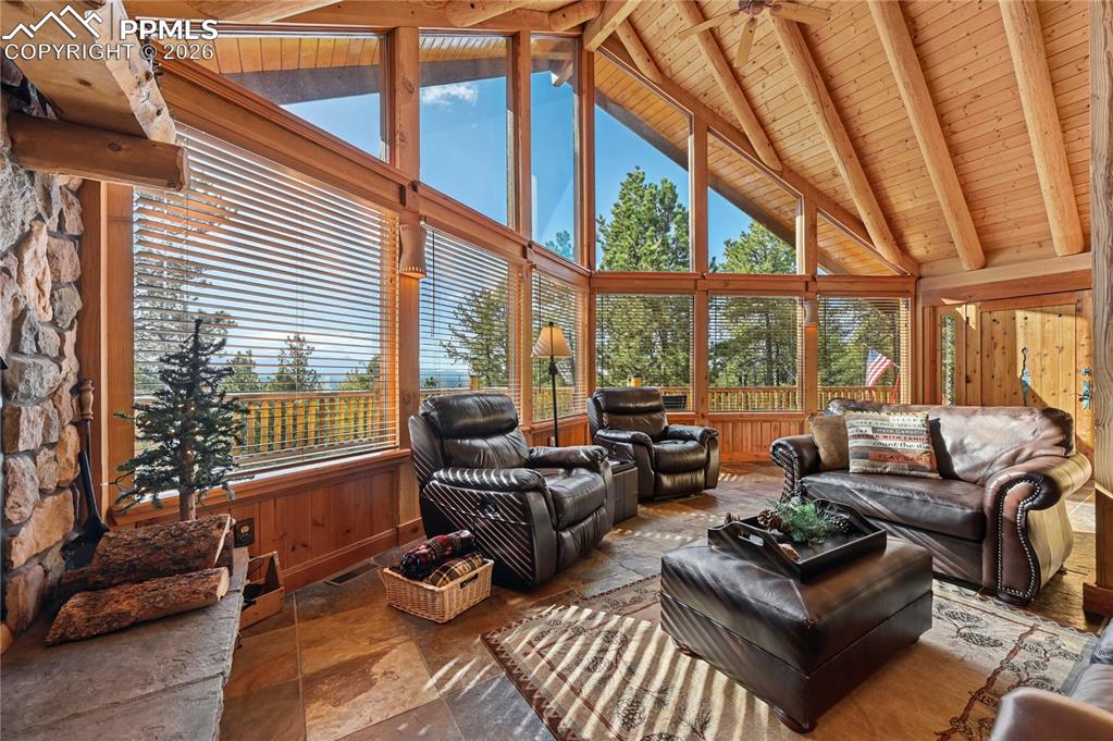 Image 10 of 43: This window wall and log ceiling blur the lines between indoors and nature.