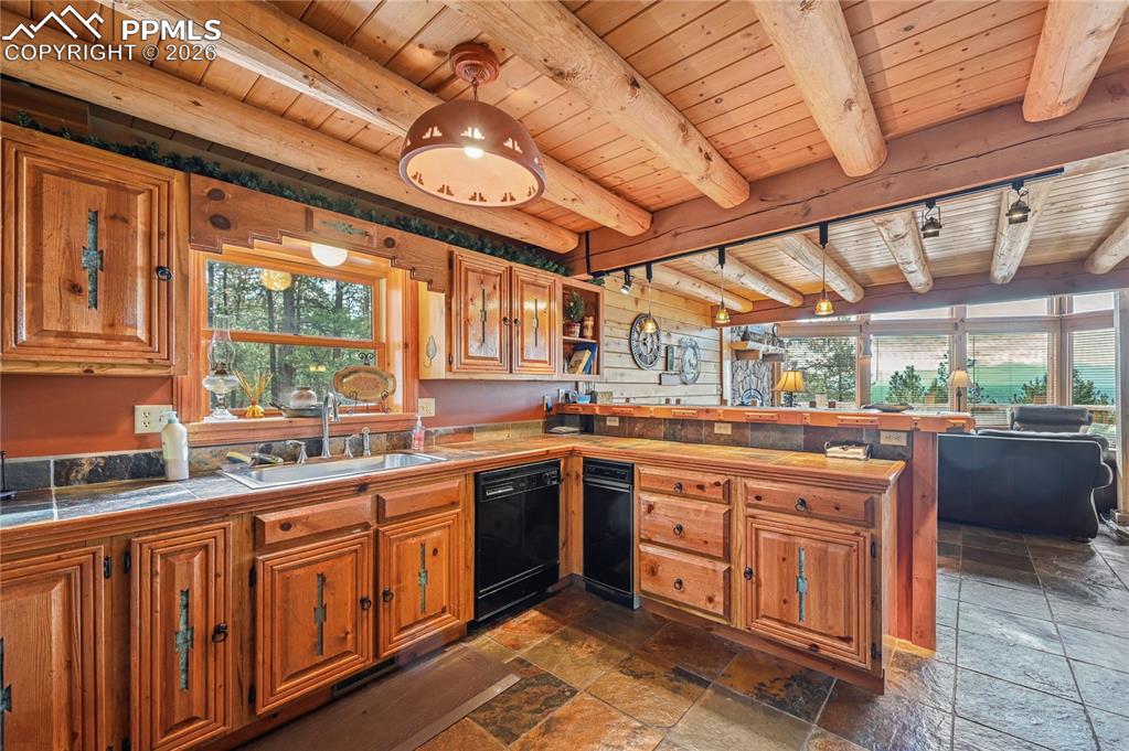 Image 15 of 43: The kitchen enjoys knotty-wood cabinetry with patinated copper Southwest in