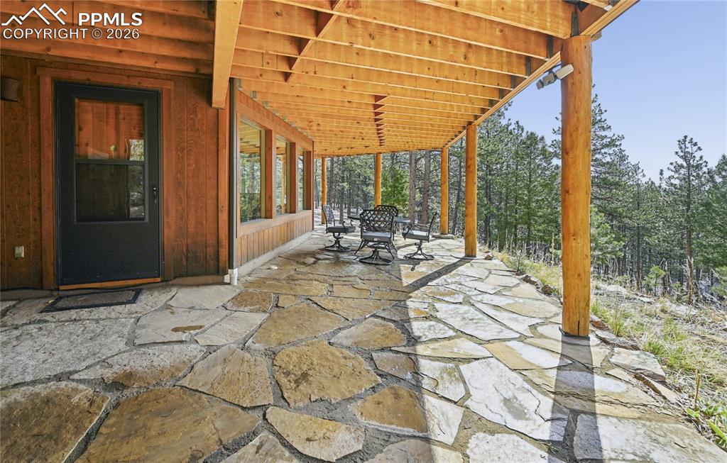 Image 33 of 43: Just outside the walk-out basement family room is a wrap-around flagstone p