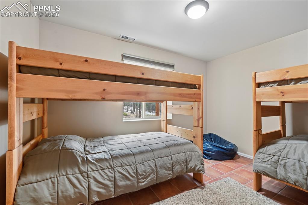 Image 35 of 43: Bedroom #5 in the basement is also set up as a bunk room with big, full-siz
