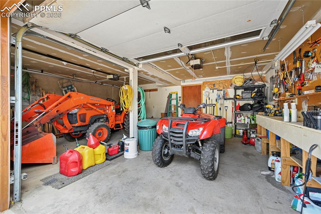 Image 40 of 43: The two-car attached garage has a great work bench, and room to park cars o