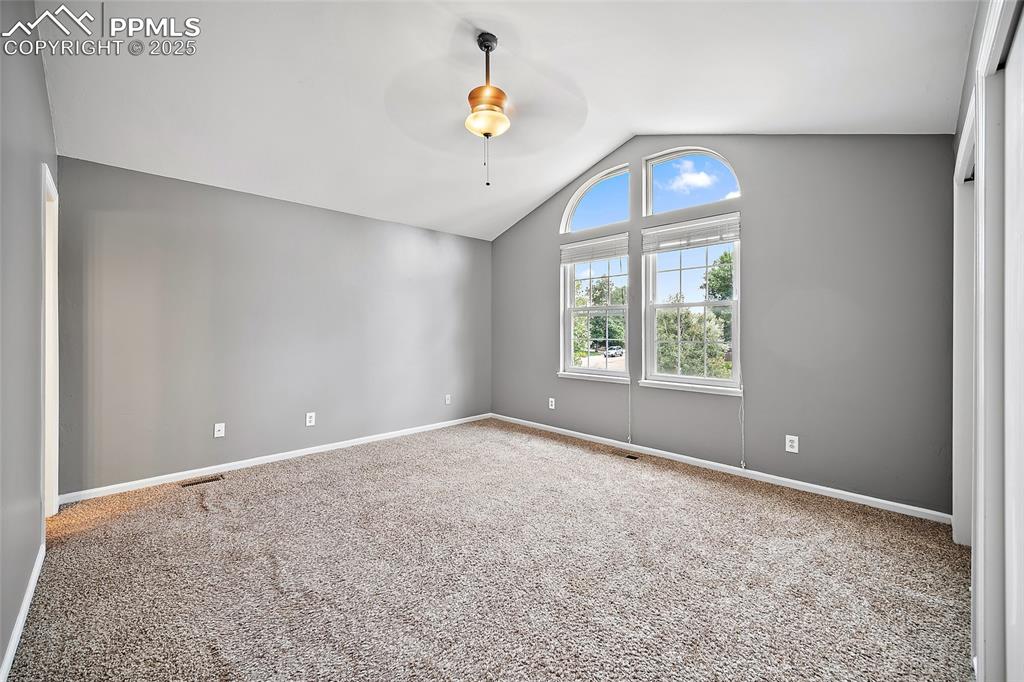 Image 29 of 50: primary bedroom with an ensuite, ceiling fan, and double closet