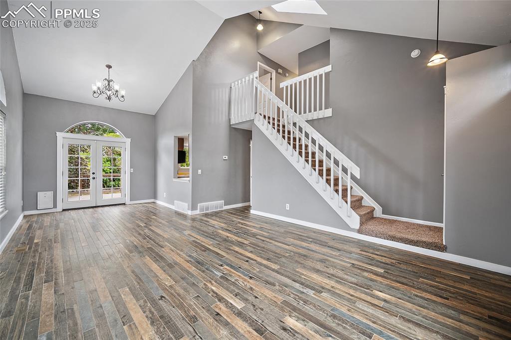 Image 6 of 50: living room with high ceilings, connected to a dining area