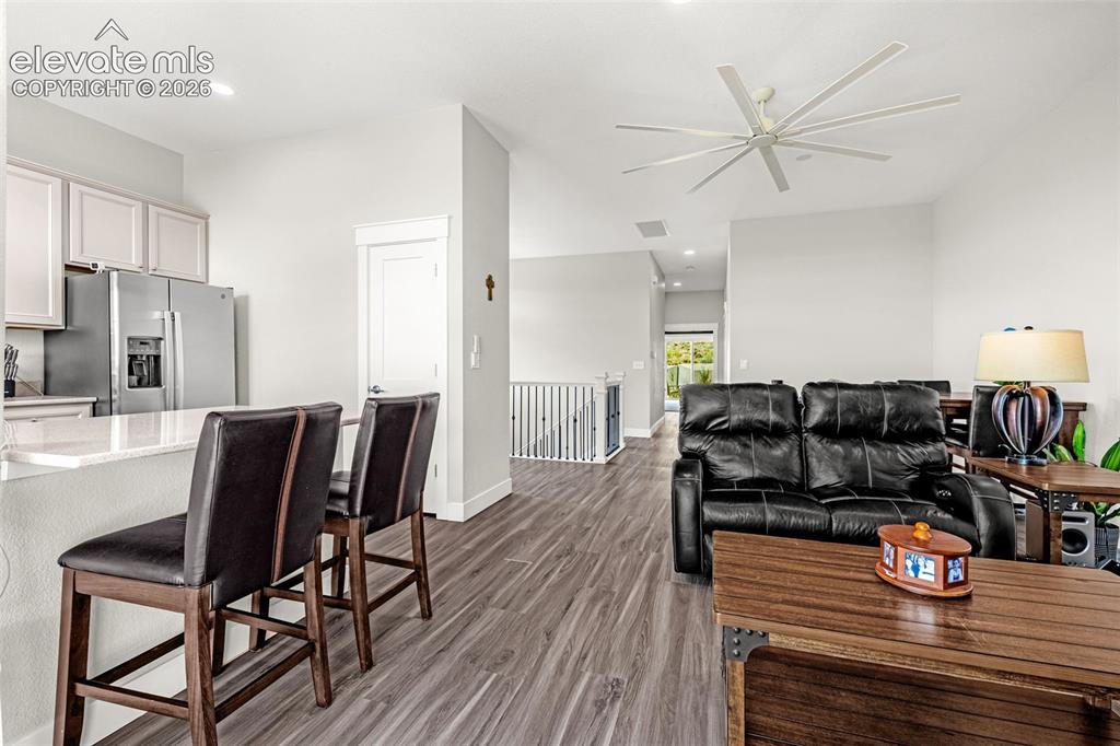 Image 20 of 33: LVP flooring, living room with gas fireplace, kitchen, and a balcony