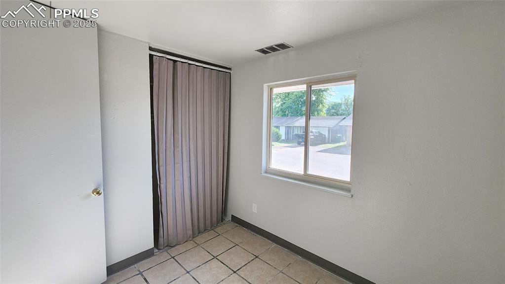 Image 11 of 15: Unfurnished room with baseboards and light tile patterned floors