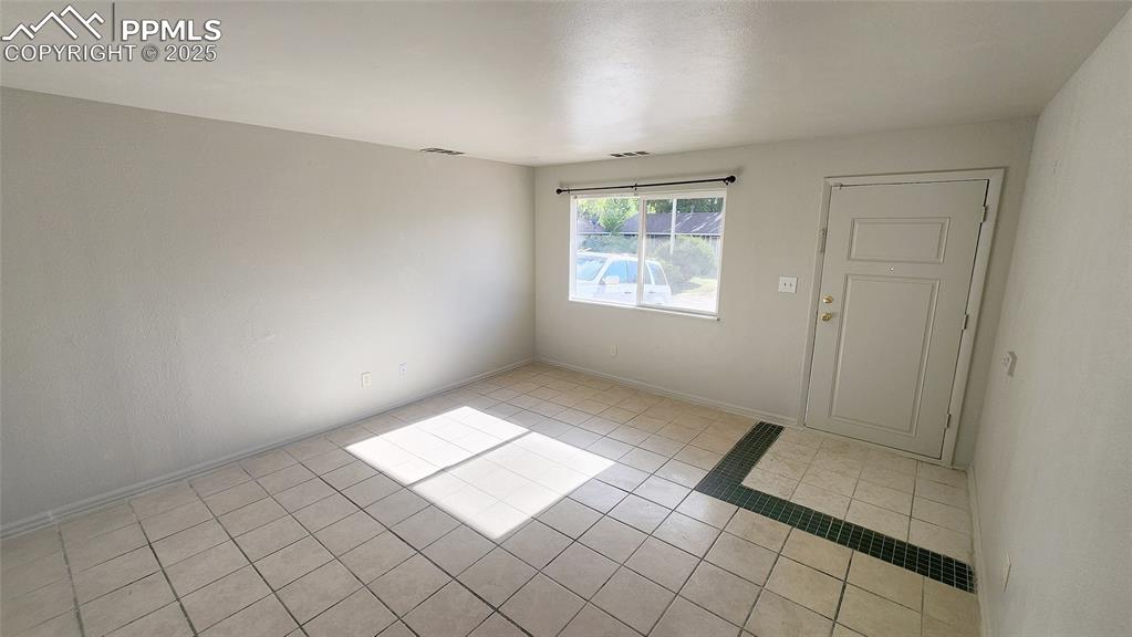 Image 4 of 15: Spare room with light tile patterned flooring and baseboards