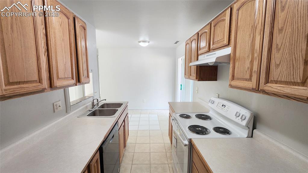 Image 6 of 15: Kitchen with white range with electric stovetop, under cabinet range hood,