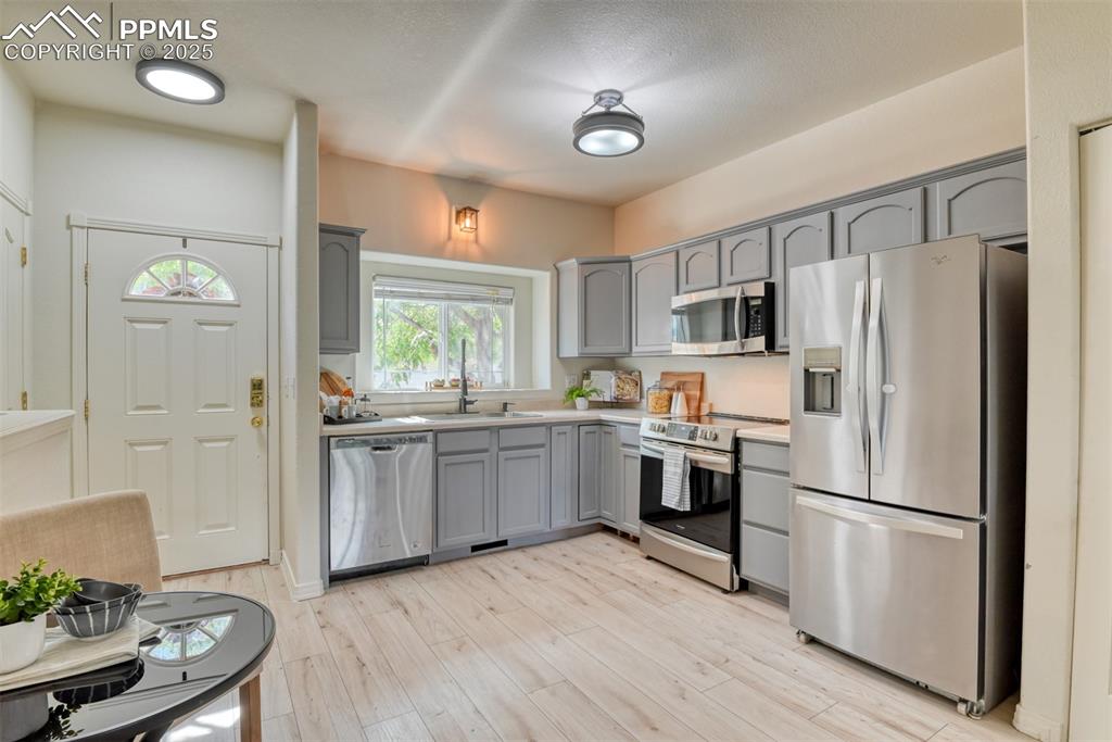 Image 2 of 46: Kitchen featuring stainless steel appliances, light countertops, gray cabin