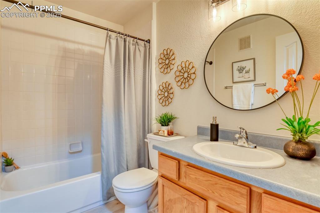 Image 26 of 46: Full bath with shower / bath combo, vanity, and a textured wall