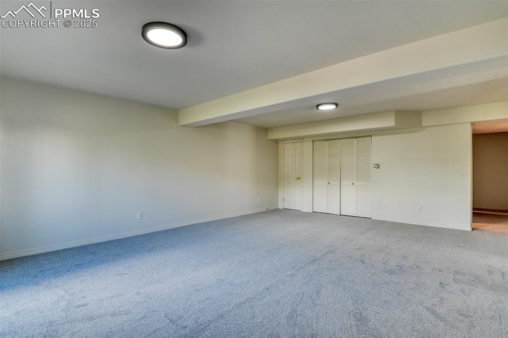 Image 33 of 46: Basement with light colored carpet and baseboards
