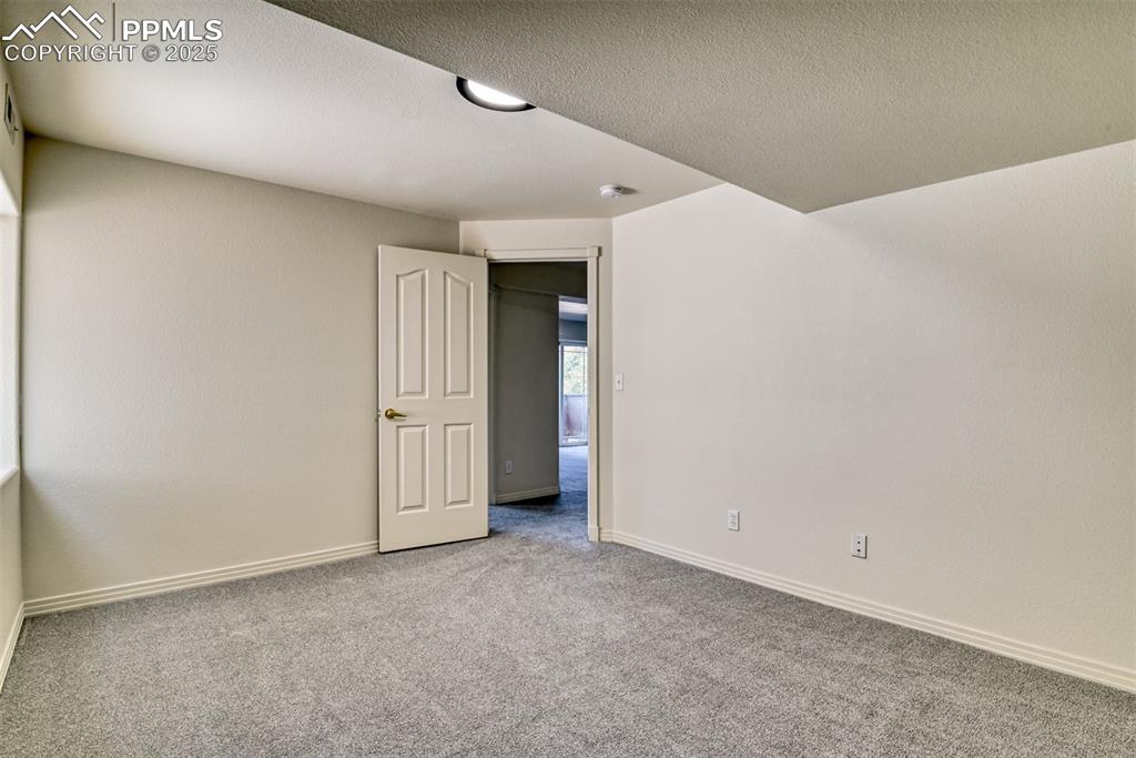 Image 42 of 46: Carpeted spare room with baseboards and a textured ceiling