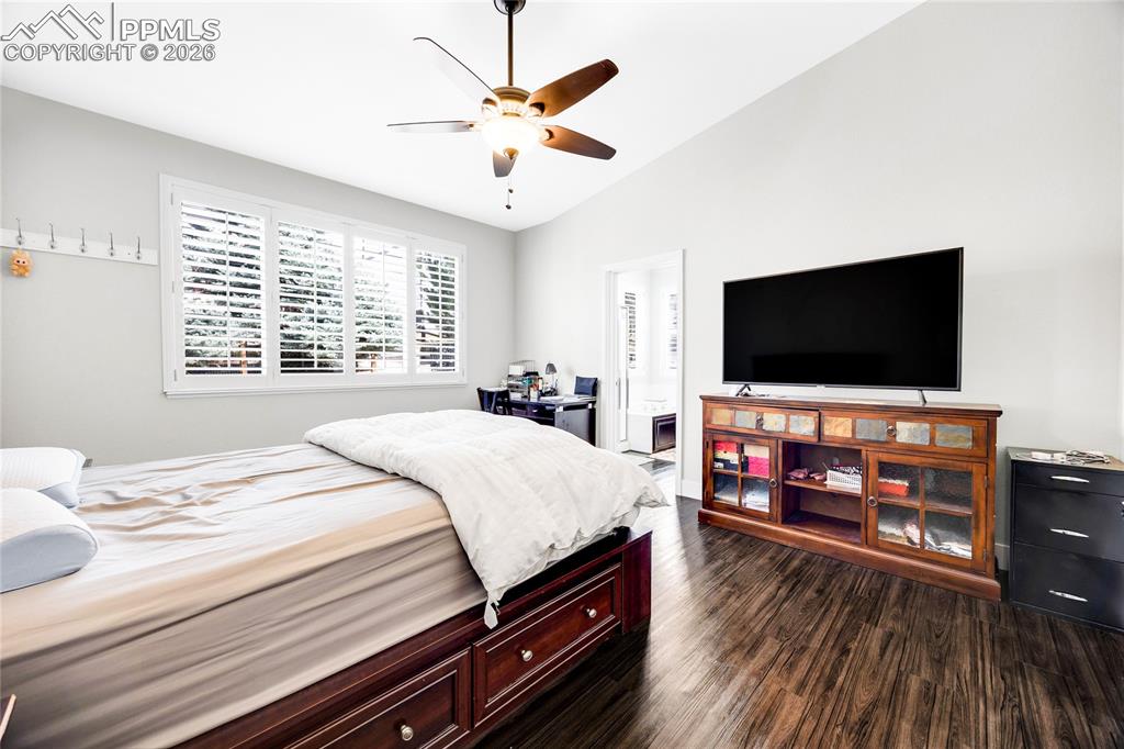 Image 17 of 37: Bedroom with dark wood-type flooring, vaulted ceiling, and a ceiling fan