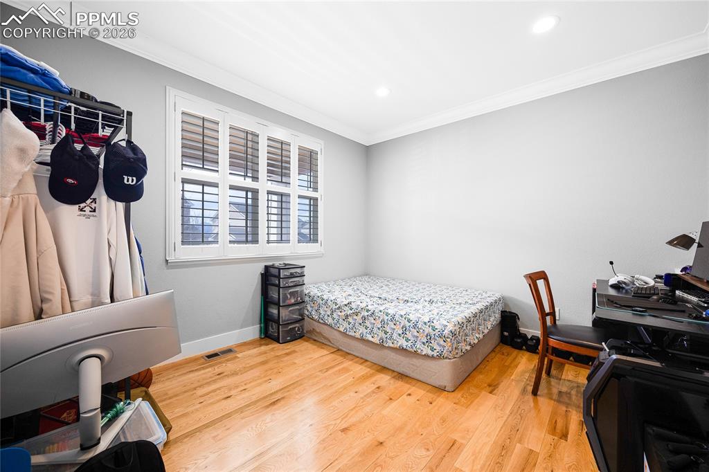 Image 20 of 37: Bedroom with crown molding, light wood-style flooring, and recessed lightin