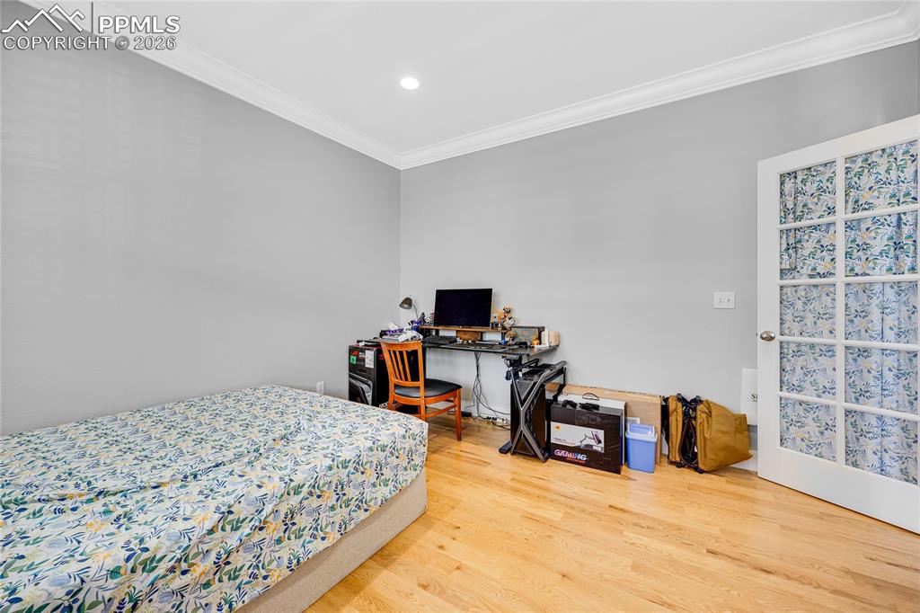 Image 21 of 37: Bedroom featuring light wood-style floors, ornamental molding, recessed lig