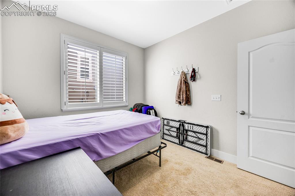 Image 27 of 37: Bedroom with light colored carpet and baseboards