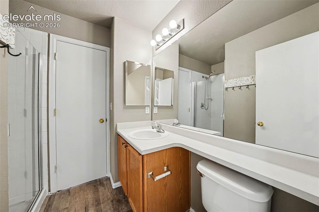 Image 14 of 31: Wood-finish flooring with a glass-enclosed shower
