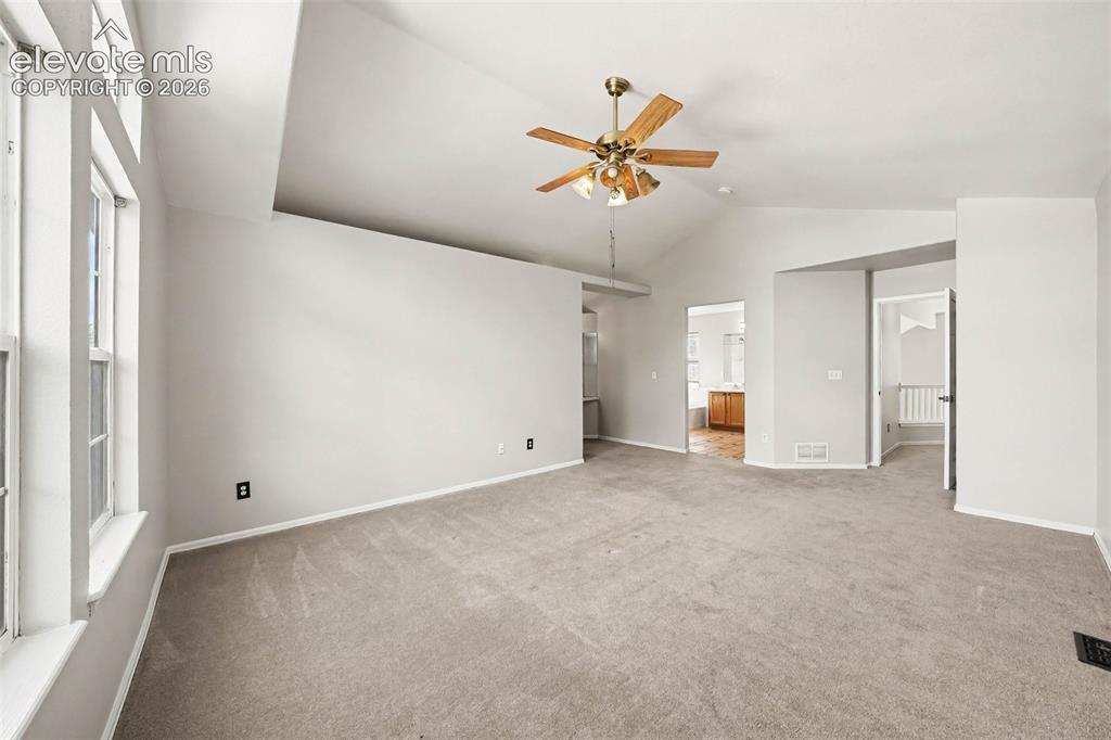 Image 16 of 31: Vaulted ceilings, a ceiling fan with integrated lighting, and light-toned w