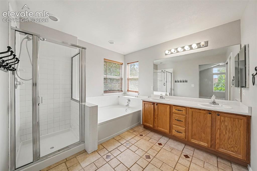 Image 17 of 31: Dual vanity with integrated sinks, full-width mirror, white tile flooring, 