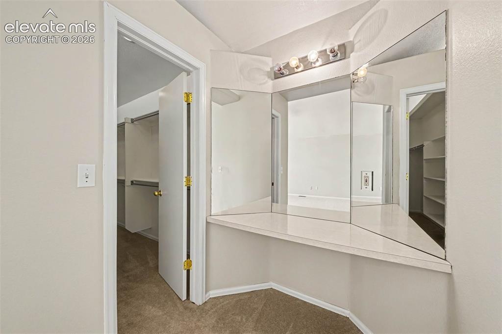 Image 18 of 31: Built-in vanity with integrated mirrors and overhead lighting