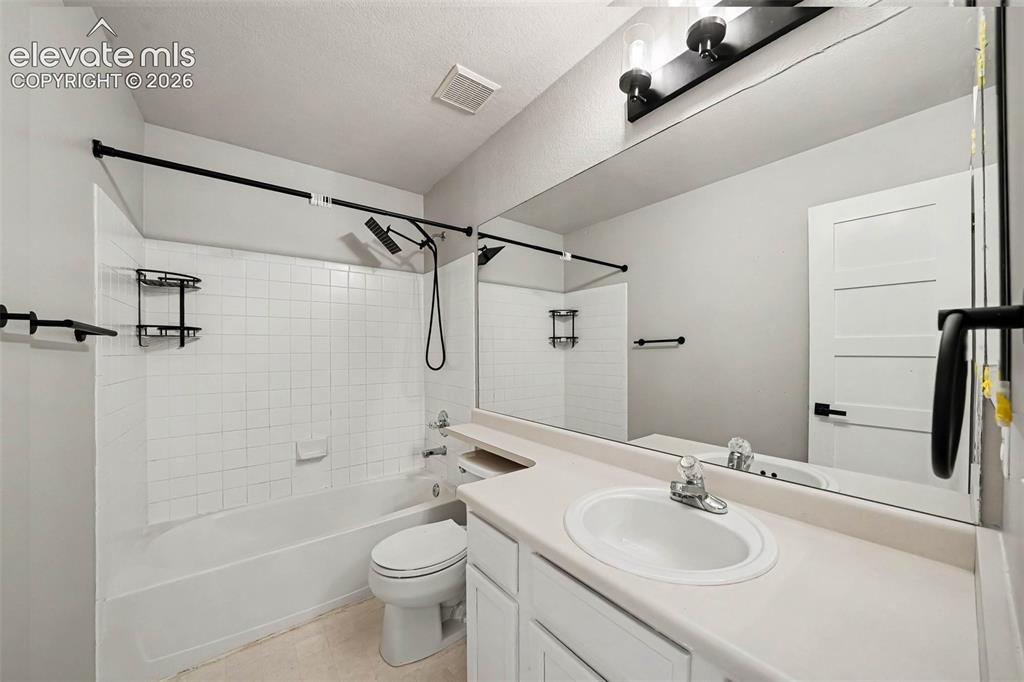 Image 23 of 31: Bathroom featuring a full-width vanity mirror, a white single-basin sink, a