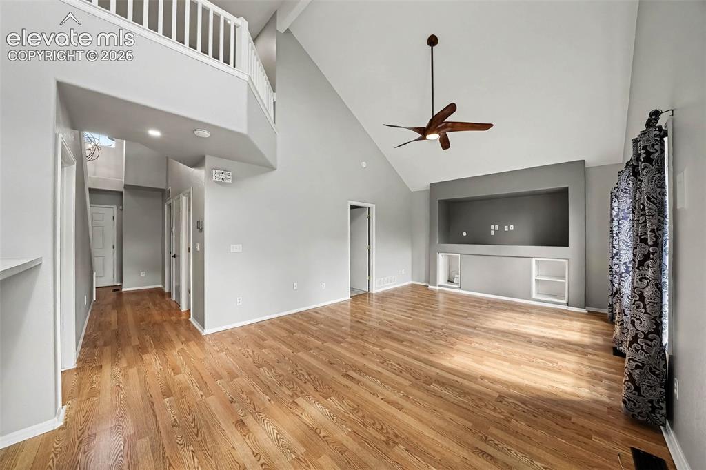 Image 5 of 31: Vaulted ceilings, wood-finish flooring, built-in media niche, ceiling fan, 