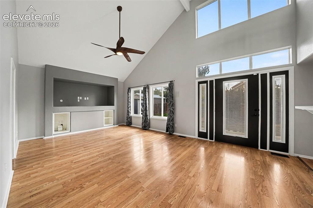 Image 6 of 31: Vaulted ceiling with an integrated ceiling fan, wood-finish flooring, built