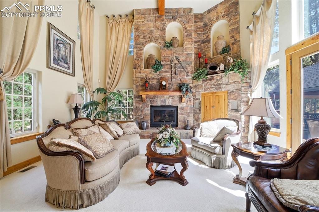 Image 18 of 50: Formal living area with a fireplace and motorized blinds