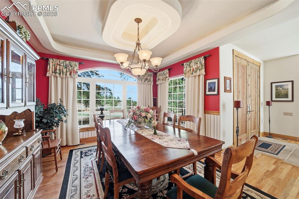 Image 21 of 50: Formal Dining Room, Wood floors and a raised coffered ceiling