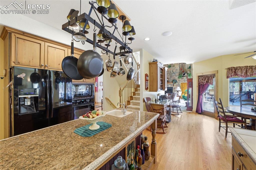 Image 23 of 50: Hanging ceiling pots and pans holder above island stays with the home