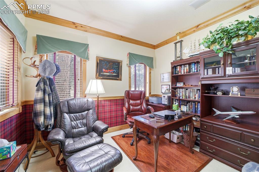 Image 29 of 50: Office space with wainscoting, crown molding, and light wood finished floor
