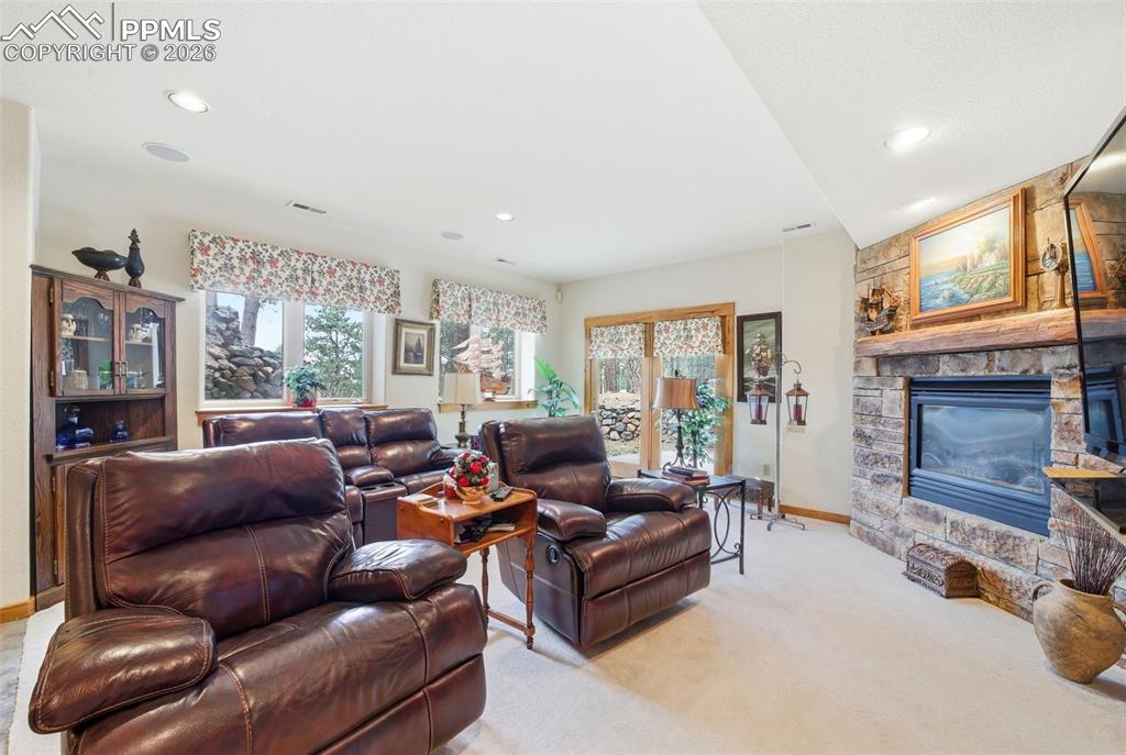Image 34 of 50: Basement Family room featuring Walkout doors, a fireplace, and recessed lig