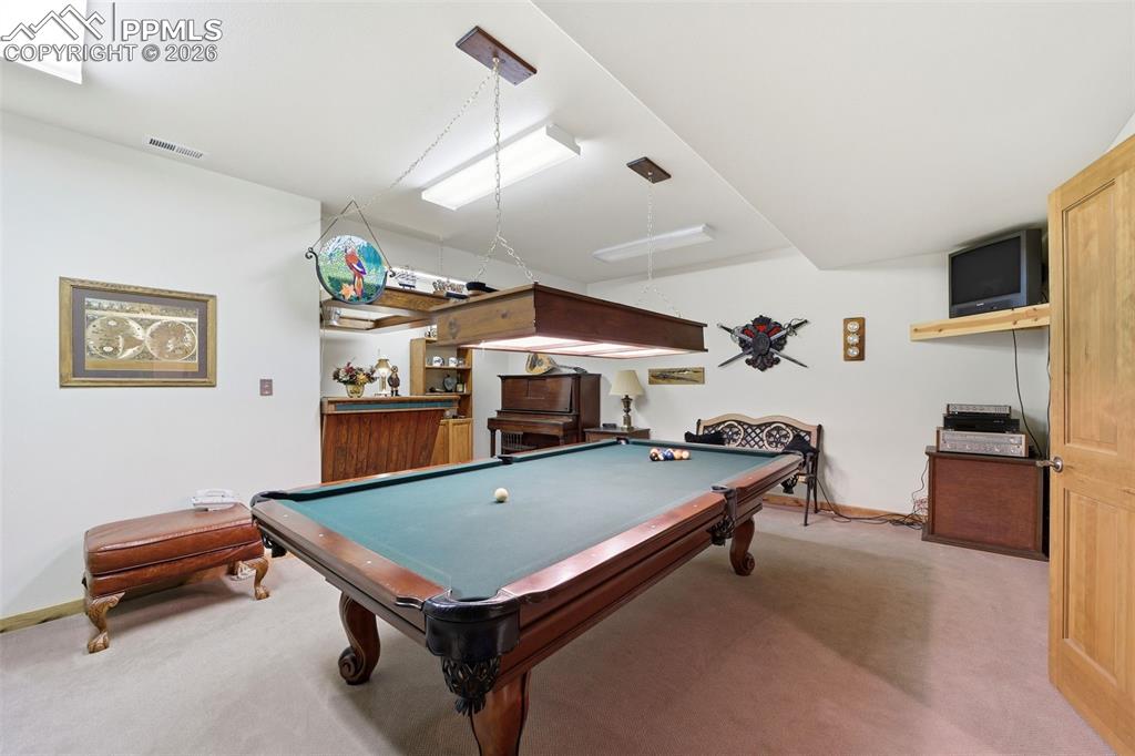 Image 37 of 50: This basement bedroom isbeing used as a game room (Pool table and dry bar n