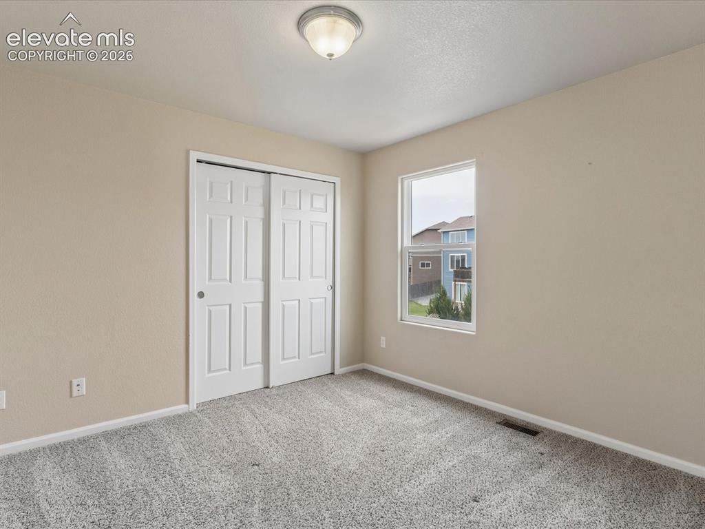 Image 10 of 23: Carpeted room with neutral-toned walls, a double-door closet, and a single 
