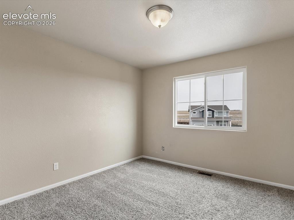 Image 13 of 23: Neutral-toned room featuring a large window with horizontal blinds