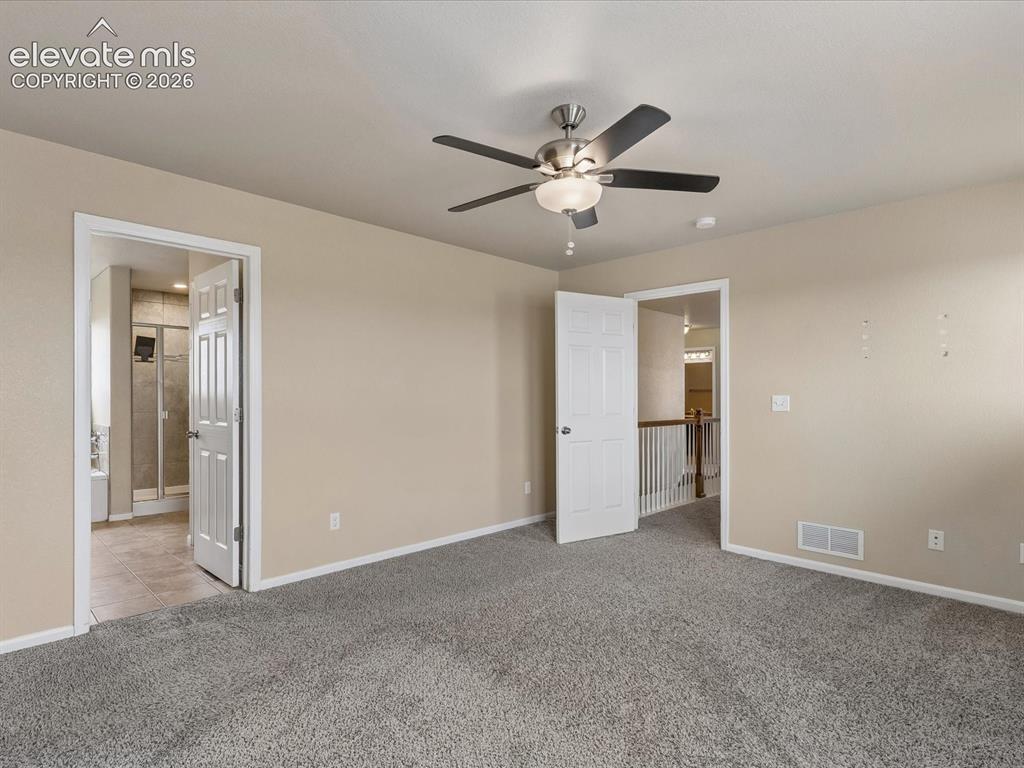 Image 16 of 23: Carpeted room featuring a ceiling fan with light fixture, neutral wall pain