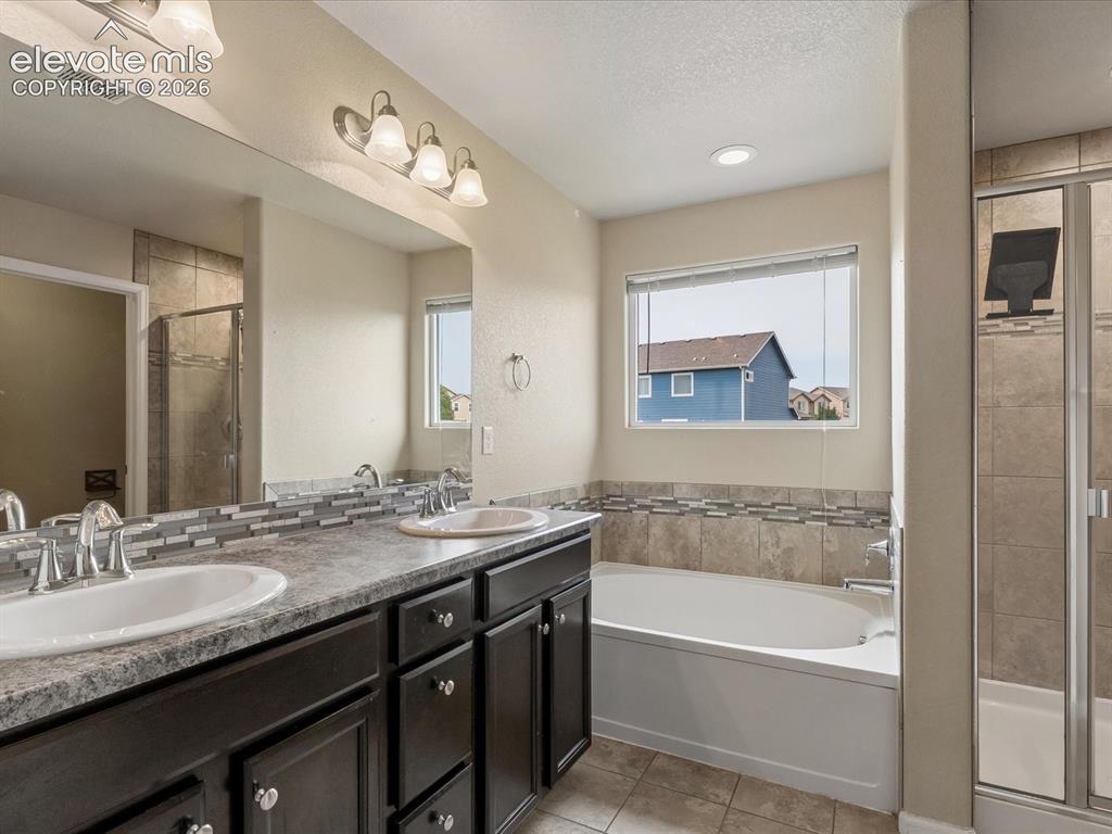 Image 17 of 23: Double vanity with dark wood-finish cabinetry, dual undermount sinks, and l
