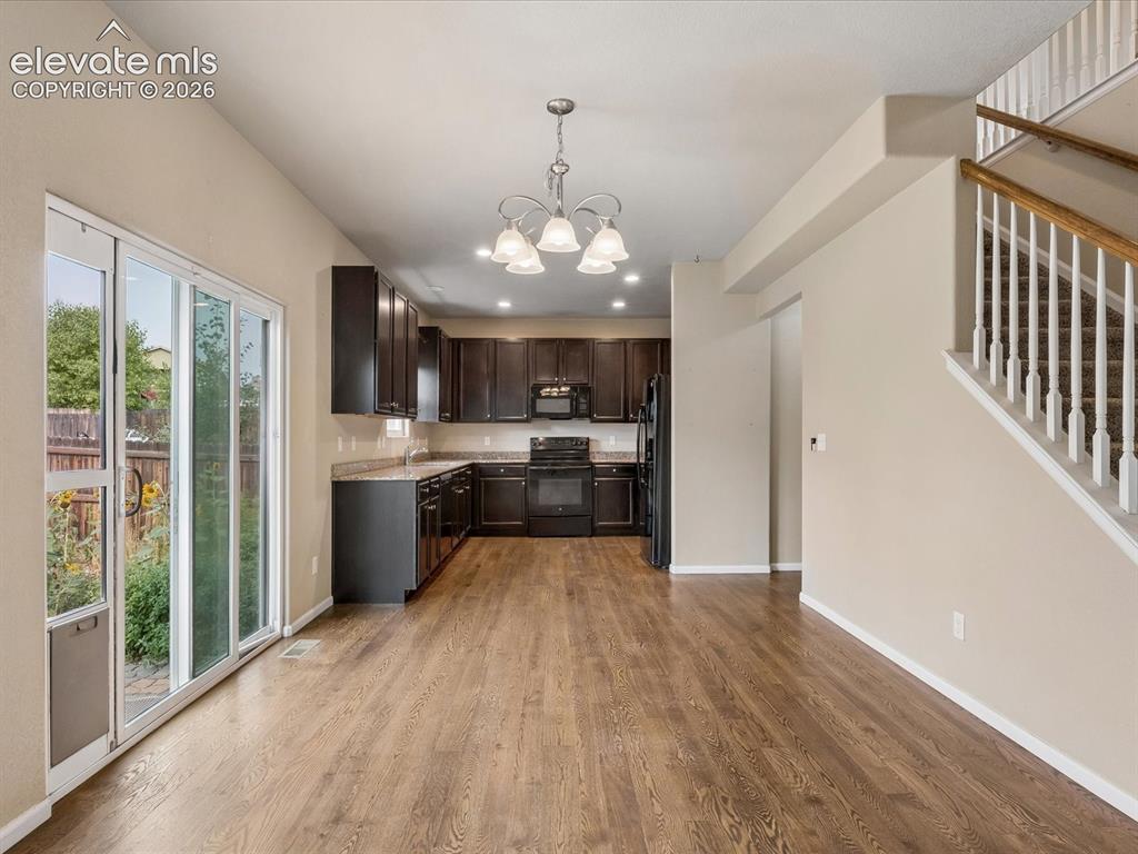 Image 5 of 23: Open-concept kitchen and dining area featuring dark wood-finish cabinetry, 