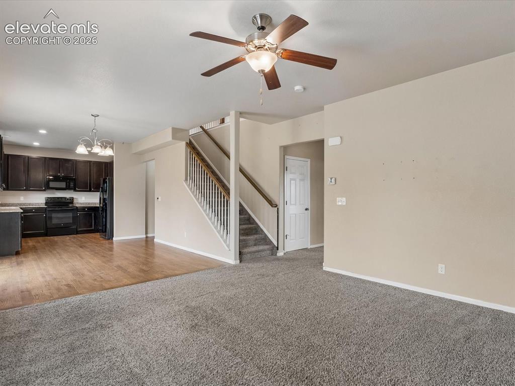 Image 6 of 23: Open concept living area featuring wood-finish flooring, dark wood cabinetr