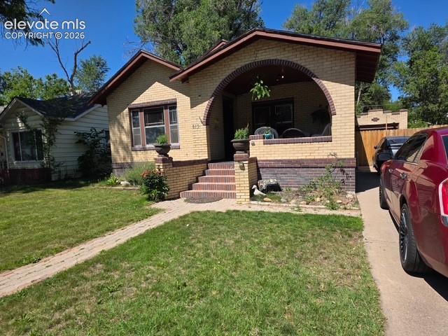 Image 1 of 22: Brick residence featuring an arched portico entry with decorative pillars,