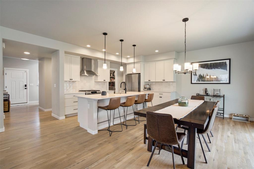 Image 13 of 43: Dining area featuring light wood finished floors, a chandelier, and recesse
