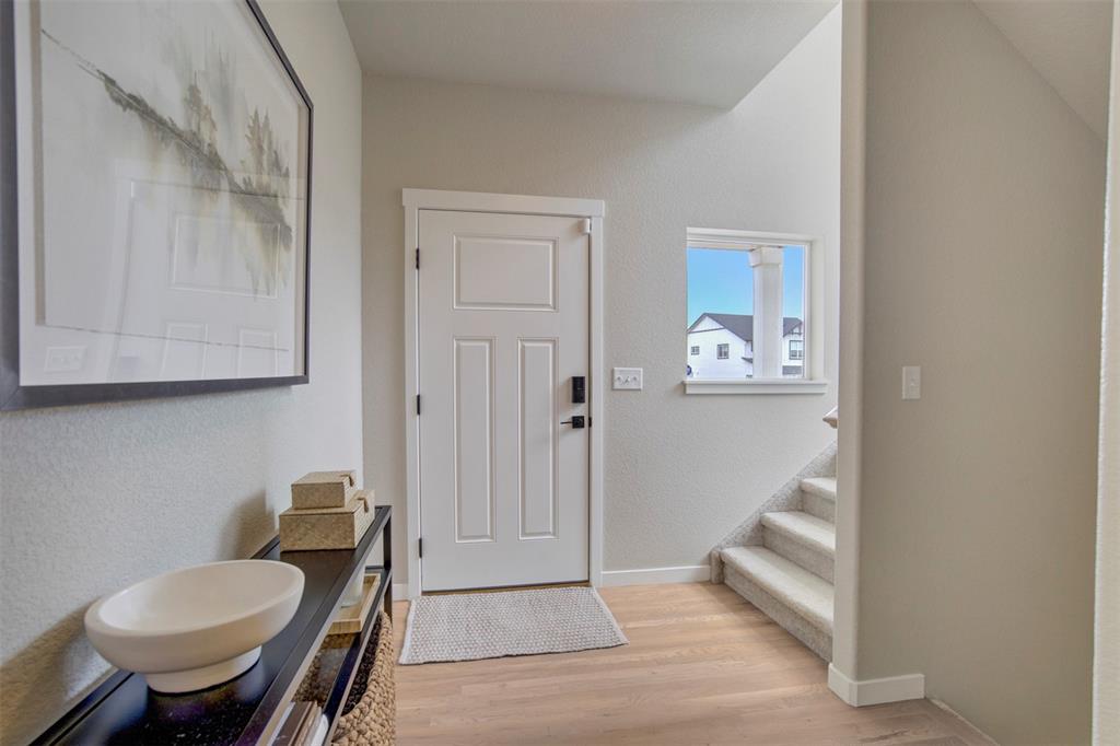Image 15 of 43: Entryway with light wood-type flooring, stairs, and a textured wall